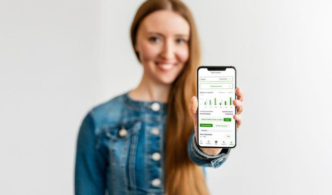 kobieta trzyma smartfon z aplikacją mobilną